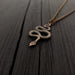Snake pendant on chain against black background | Moon Raven