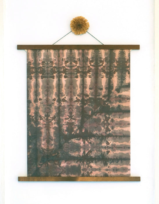 white dragonball print hanging in a poster frame that consists of two dark wooden bars running along the top and bottom of the print. A dried chrysanthemum is affixed to the tip of the string that's holding the print to the wall