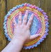 Photograph of the altar cloth with the creator's hand on it, for scale.