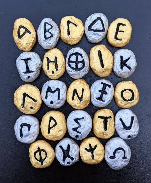 Photograph of a set of Greek Alphabet Oracle stones painted in gold and silver.