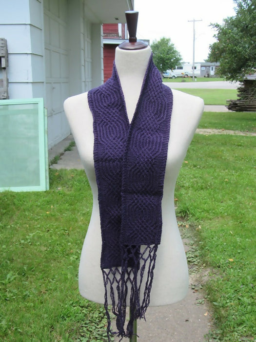 dark purple scarf with a narrow cable motif and fringe
