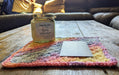 Photograph of the altar cloth with the candle and tarot card on it, taken from a different angle.