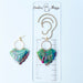 A pair of handmade fan-shaped polymer clay earrings displayed on a white background. The earrings feature gold-plated ball posts and hoops, with semi-transparent rainbow-colored clay and green etched fan-like lines. The marbling effect shows swirls of pink, blue, green, orange, and white.
