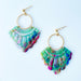 A pair of handmade fan-shaped polymer clay earrings displayed on a white background. The earrings feature gold-plated ball posts and hoops, with semi-transparent rainbow-colored clay and green etched fan-like lines. The marbling effect shows swirls of pink, blue, green, orange, and white.