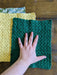 Photograph of the unfolded kitchen towels with the creator's hand on them, for scale.