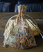 Photograph of a set of stitch markers in a golden tulle bag.