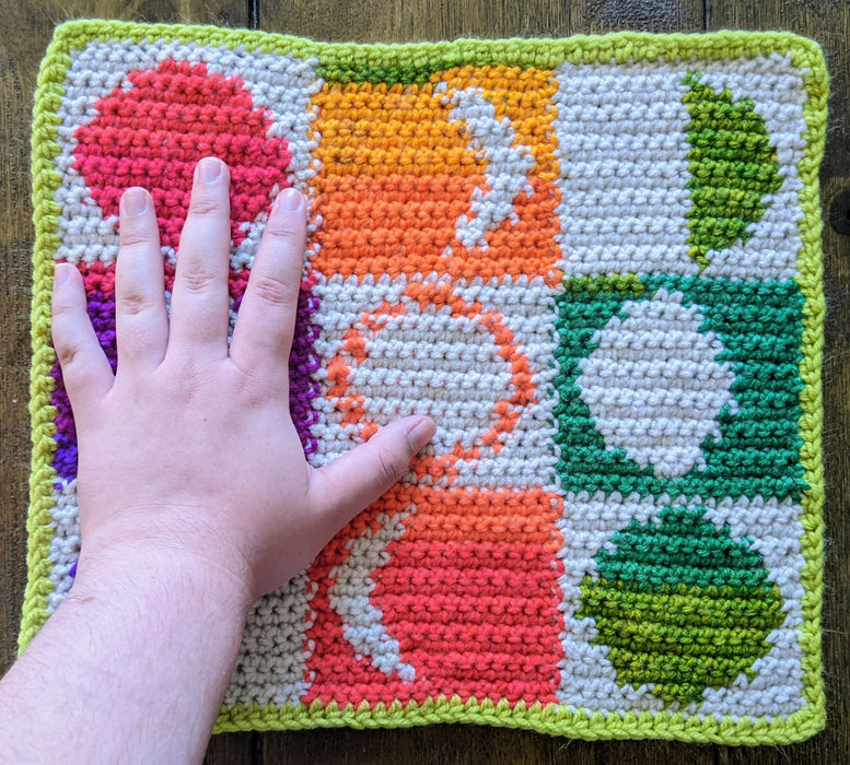 Photograph of the rainbow tarot cloth with the creator's hand on it for scale.
