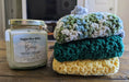 Photograph of the stacked kitchen towels next to a candle, for scale.