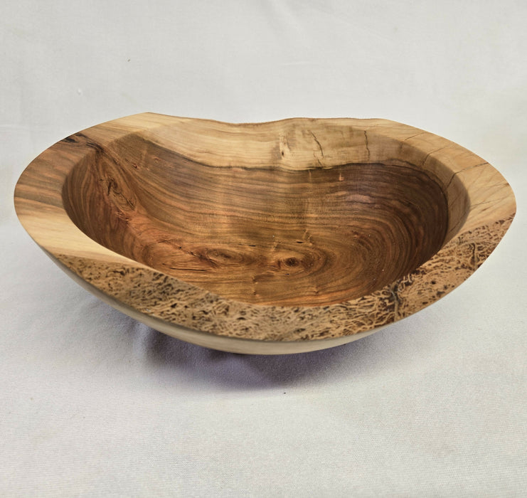 A close picture of a natural edge wooden cherry bowl
