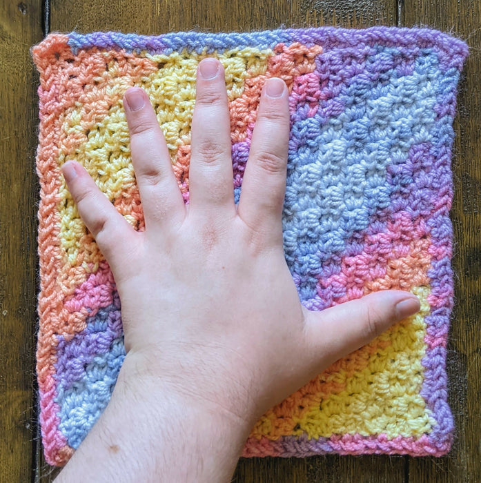 Photograph of the altar cloth with the creator's hand on it, for scale.