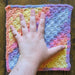 Photograph of the altar cloth with the creator's hand on it, for scale.