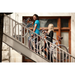 Two people carrying their bikes up a tall set of stairs using the "little lifter" bicycle handle