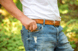 Short GIF video showing a man sliding a Mini Deluxe leather travel cribbage board into the front right pockets of his denim jeans.