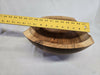 A picture of a wooden cherry bowl with a ruler on top measuring 11 inches