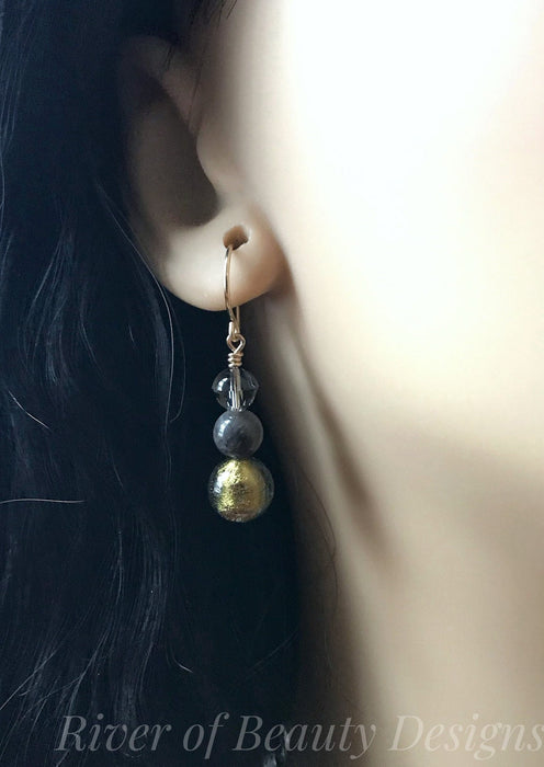 Elegant 3-ball dangle earrings, shown on a mannequin. Colors are translucent gray, grayish black, and gold.